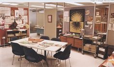 an office filled with desks and chairs next to bookshelves on the wall