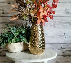 two vases filled with flowers sitting on top of a table