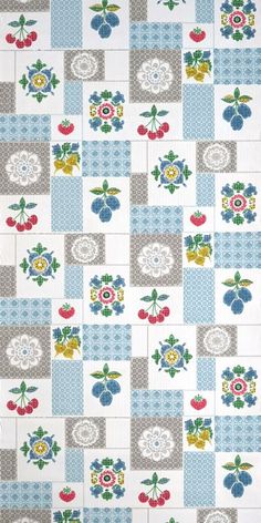 a blue and white patchwork quilt with flowers on the front, in different colors