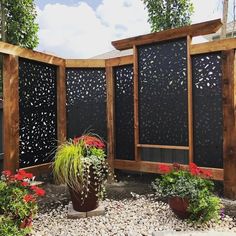 a wooden fence surrounded by potted plants