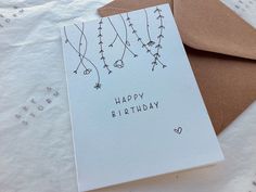 a white card with black writing on it sitting next to an envelope that says happy birthday