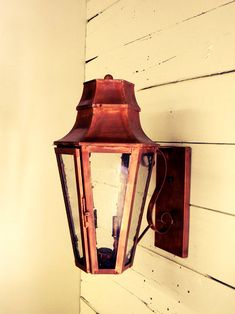 an old fashioned lantern hanging on the side of a house