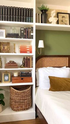 a bed sitting in a bedroom next to a white book shelf with books on it