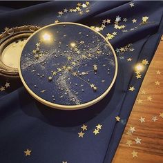 a clock with stars on it sitting on a blue table cloth next to a mirror