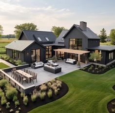 an aerial view of a modern house with patio and outdoor furniture in the foreground