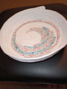 a white and blue bowl sitting on top of a black chair