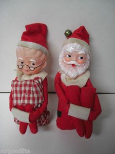 two santa claus dolls are standing next to each other