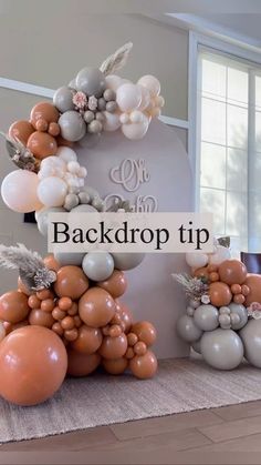 balloons are arranged in the shape of an arch with flowers and leaves on it, as well as words that read back drop tip