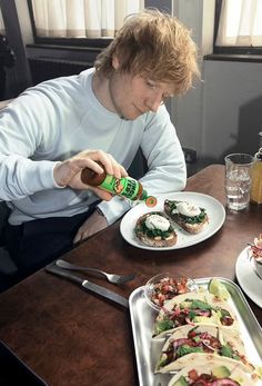 a man sitting at a table with plates of food