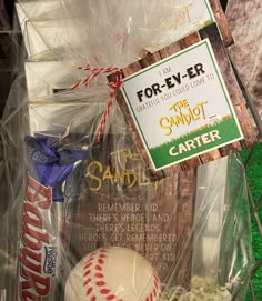 a baseball, candy bar and other items are on display in a plastic bag with a sign that says for - ever the sandlot center