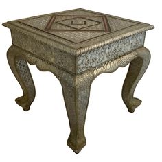 a small table with an intricate design on the top and bottom, sitting in front of a white background