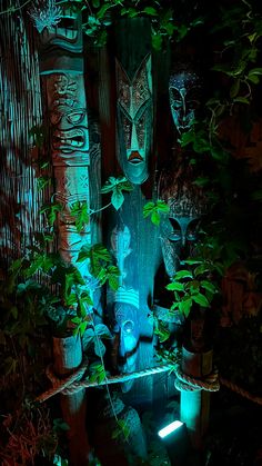 a wooden statue surrounded by greenery in the dark