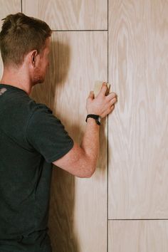 a man is working on a wall with wood paneling