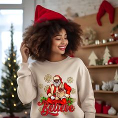 Black Santa Claus Christmas  Celebrate the season with our charming Christmas sweatshirt featuring a lovable Black Santa Claus. This African American Christmas shirt is a perfect way to spread holiday joy and diversity while looking cute and festive. Tis the season to share the spirit of inclusion and merriment with this unique and heartwarming sweatshirt A sturdy and warm sweatshirt bound to keep you warm in the colder months. A pre-shrunk, classic fit sweater that's made with air-jet spun yarn for a soft feel and reduced pilling. * 50% cotton, 50% polyester * Pre-shrunk * Classic fit * Air-jet spun yarn with a soft feel and reduced pilling * Double-needle stitched collar, shoulders, armholes, cuffs, and hem For Matching Tote Bag and other unique items please visit our shop https://www.et Black Santa Claus, Retro Christmas Shirt, American Christmas, Christmas Tote Bags, Santa Shirt, Holiday Apparel, Christmas Tote, Black Santa, Charming Christmas