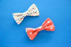 two small bow ties sitting on top of a blue surface