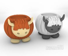 two small toy animals sitting next to each other on a white surface, one with long hair and the other with horns