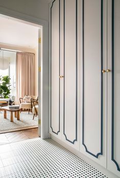 an open door leading to a living room with white walls and blue trim on the doors