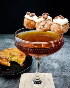 a glass filled with liquid and pastries on top of a table