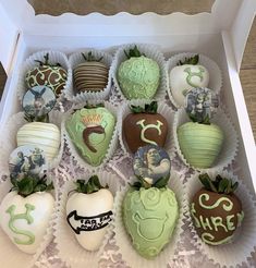 a box filled with chocolate covered strawberries in green and white designs on top of each other