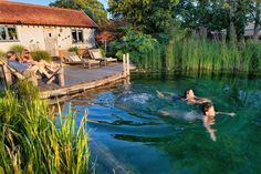 two people are swimming in the water next to a dock