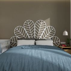 a bed with blue sheets and pillows in a small room next to a wall mounted headboard