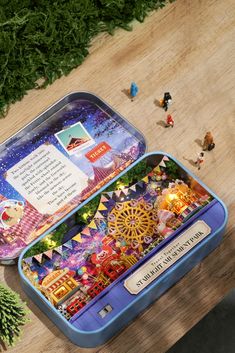 an open tin box sitting on top of a wooden table next to toy figurines