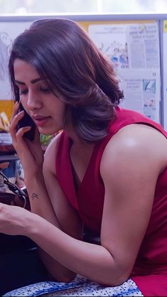 a woman in a red dress talking on a cell phone