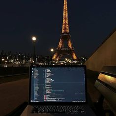 a laptop computer sitting in front of the eiffel tower