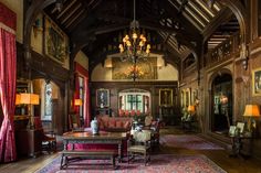 an ornate living room with chandelier, couches and rugs on the floor