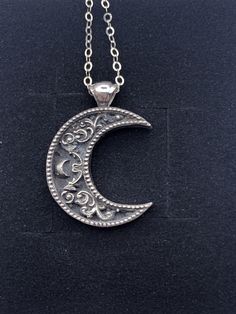 "A crescent shaped moon with a solid bail. Inside the moon is a floral scrollwork pattern. We cast this is solid sterling silver, with a dark patina to really make it pop! Pendant including bail is 26mm high and 20mm wide. This item is custom made to order. That means it may take an extra second or two to make your entire piece by hand. We try to beat shipping estimates, but its just a one woman team in this shop! Our supplier of casting grain uses SCS-certified 100% recycled metal. We make ever Moon Pendant Necklace Silver, Engraved Sterling Silver Crescent Jewelry, Vintage Moon Shaped Sterling Silver Jewelry, Vintage Sterling Silver Moon Jewelry, Vintage Moon-shaped Sterling Silver Jewelry, Silver Crescent Filigree Jewelry, Silver Half Moon Jewelry Engraved, Silver Half Moon Engraved Jewelry, Silver Crescent Jewelry With Oxidized Finish