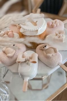 some cupcakes are sitting on a table with white frosting and pink decorations