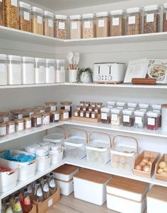 an organized pantry with lots of food and storage bins on the shelves in front of it