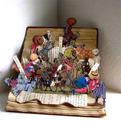 an open book with cutouts of people and animals on it sitting on top of a table