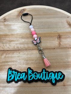 a wooden sign that says break boutique with a tassel hanging from it's end