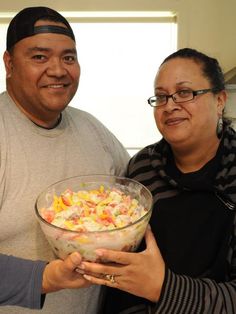 a man and woman holding a bowl of food