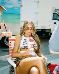 a woman sitting in a chair holding a drink