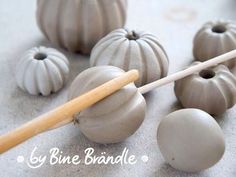 some gray ceramic pumpkins and a wooden stick