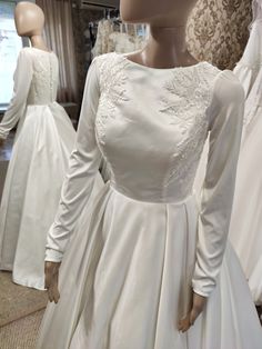 a mannequin is dressed in white wedding gowns