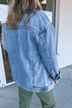 Oversized, denim, trucker jacket. This boxy silhouette is perfect for layering and legging styles. Silver metal buttons line the front and are featured on the pockets. Traditional and timeless collared neckline and yoke across the back. Light/medium wash jean material that is slightly weighted but soft and stretchy. We recommend sizing down if you're traditionally between sizes. - 100% cotton Light Wash Button-up Denim Jacket, Relaxed Fit Medium Wash Denim Jacket For Day Out, Trendy Dark Wash Denim Jacket, Trendy Denim Blue Jacket For Everyday, Trendy Dark Wash Denim Jacket For Everyday, Trendy Medium Wash Denim Jacket With Pockets, Relaxed Fit Medium Wash Denim Jacket With Frayed Hem, Dark Wash Denim Vest With Pockets For Day Out, Trendy Medium Wash Button-up Denim Jacket