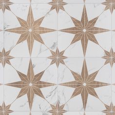 a white and brown tiled floor with star designs on the top, along with some gold accents