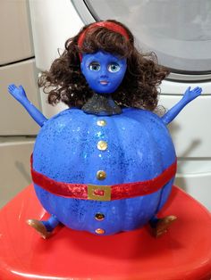 a blue doll sitting on top of a red chair