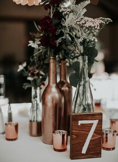 vases with flowers and candles on a table