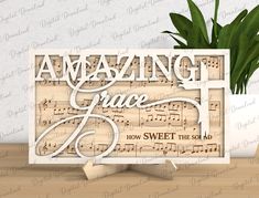 a card with the words amazing grace and music notes on it, sitting next to a potted plant