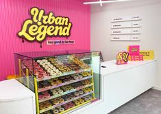 a display case filled with lots of donuts in front of a sign that says urban legend