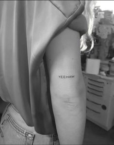 a woman's arm with the word yeee - haw tattooed on it