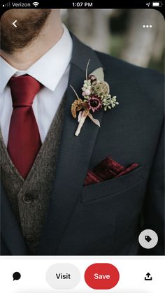 a man in a suit with a red tie and boutonniere