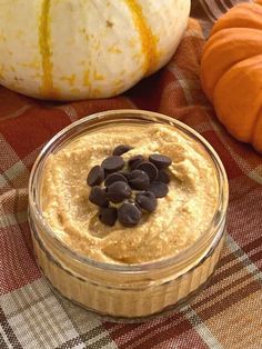 a glass bowl filled with oatmeal and chocolate chips next to pumpkins