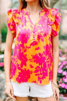 This blouse is so pretty with those vibrant hues! We love a floral print in the summer too! This blouse is going to look great for work, dinner plans, honestly just any day of the week! This blouse features a partial button down neckline with ruffled detailing, short ruffled sleeves, and a floral print. Material has no amount of stretch.Model is wearing the small. Vibrant Tropical Print Summer Blouse, Summer Vibrant Tropical Print Blouse, Vibrant Summer Blouse With Tropical Print, Summer Orange Tops With Bold Print, Orange Bold Print Summer Top, Orange Tops With Bold Print For Summer, Spring Vibrant Tropical Print Blouse, Vibrant Tropical Print Spring Blouse, Vibrant Tropical Print Blouse For Spring