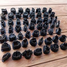 a bunch of black objects sitting on top of a wooden table next to each other