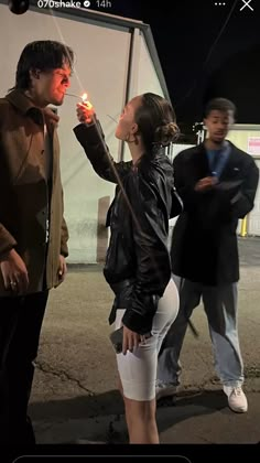 a man and woman standing next to each other holding a lit candle in their hands